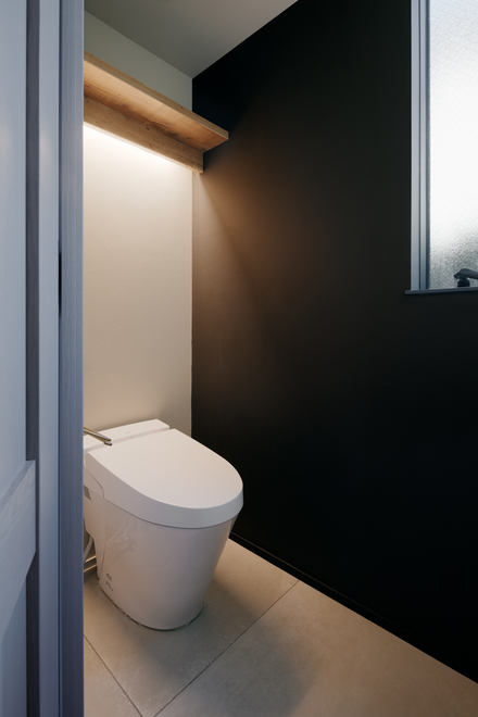 黒色の壁面がポイントのトイレ。間接照明でシンプルながらも素敵なトイレになっています。