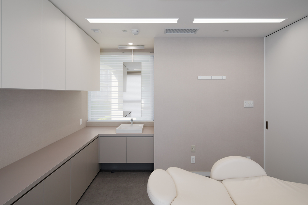 診察室内の専用の洗面台。窓からの採光を活かすために窓前の天井から吊られた鏡が特徴的です。